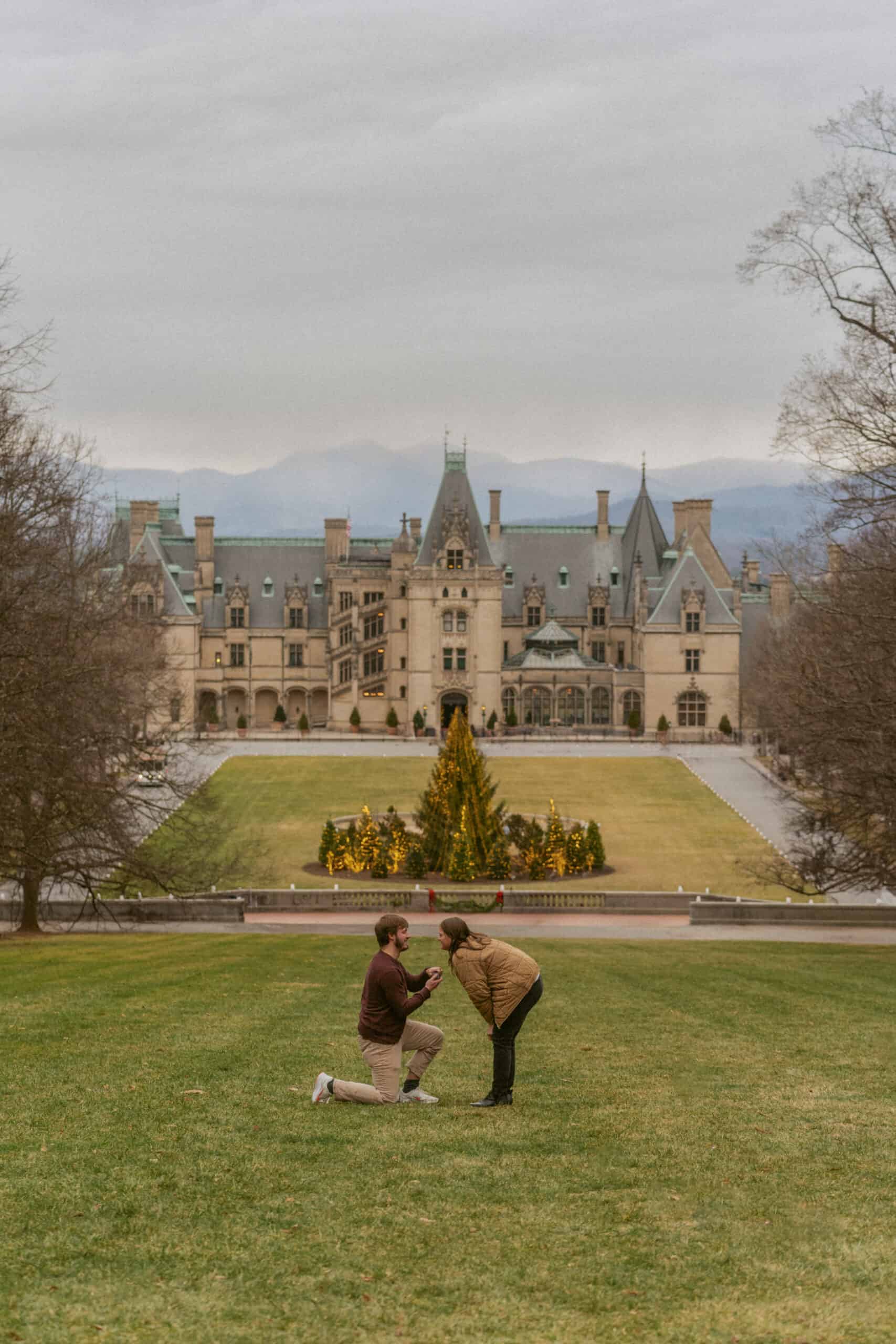 man proposing to woman in front of Biltmore house