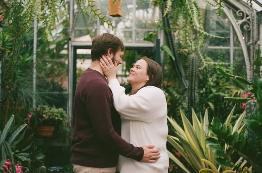 couple standing in front of plants at the Biltmore after their proposal