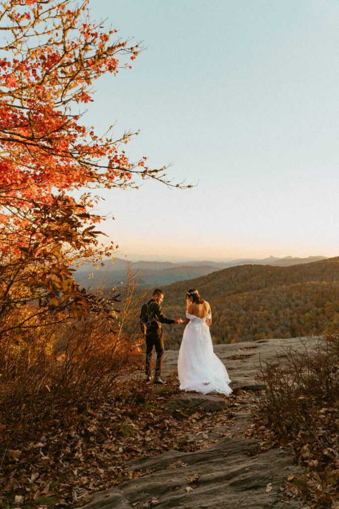 groom leading bride on path on mountain to elope in asheville