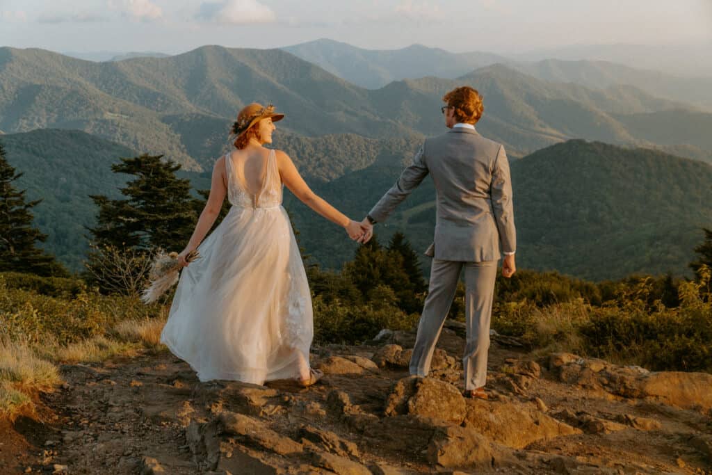 couple holding hands wearing bridal attire eloping in asheville