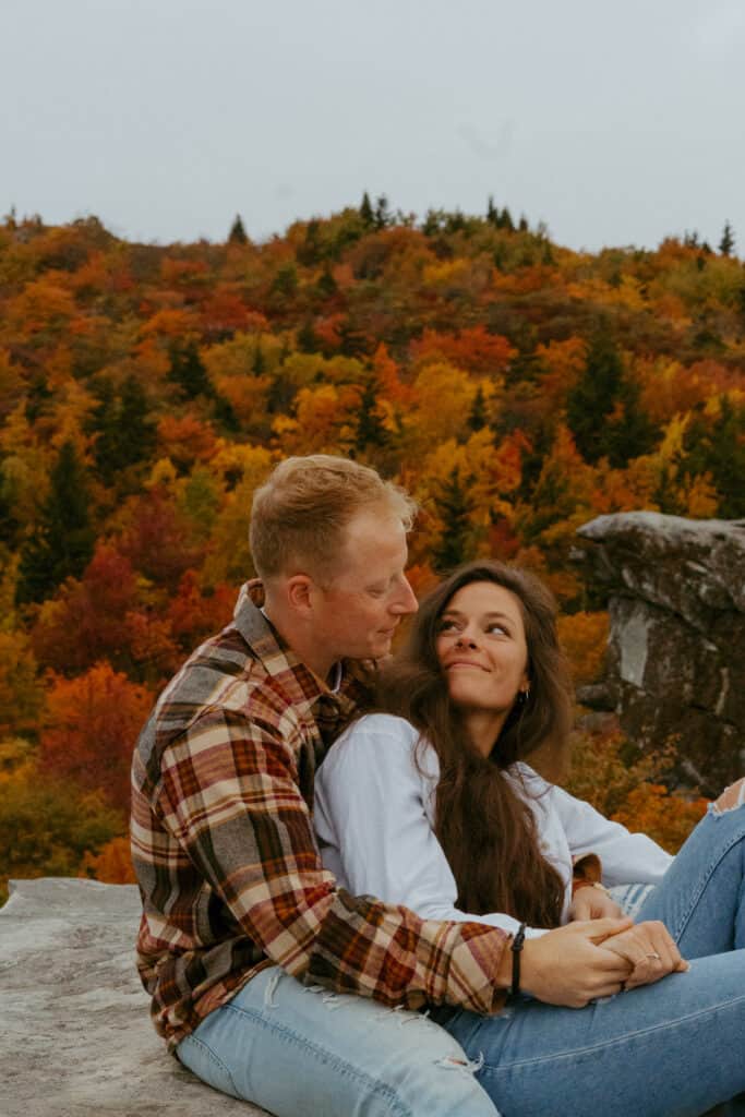 couple sitting on mountain for their asheville engagement photos