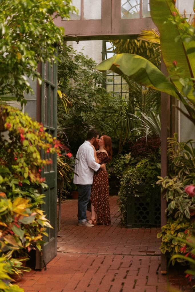 couple kissing in greenhouse conservatory
