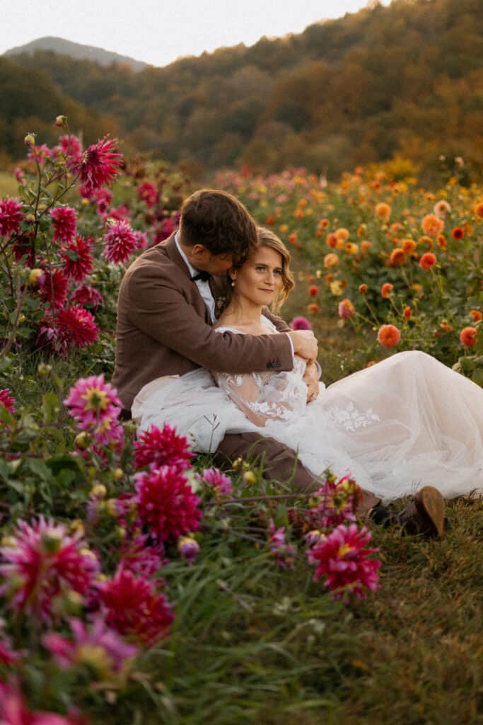 wedding couple laying down in flower field in asheville venue