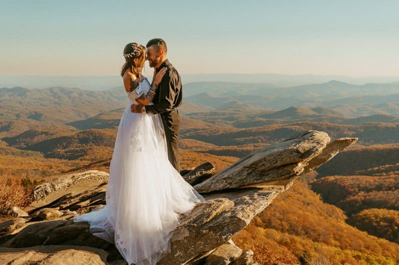 married couple standing on mountain in wedding attire for asheville elopement photographer