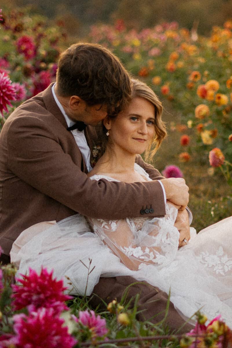 wedding couple laying down in flower field