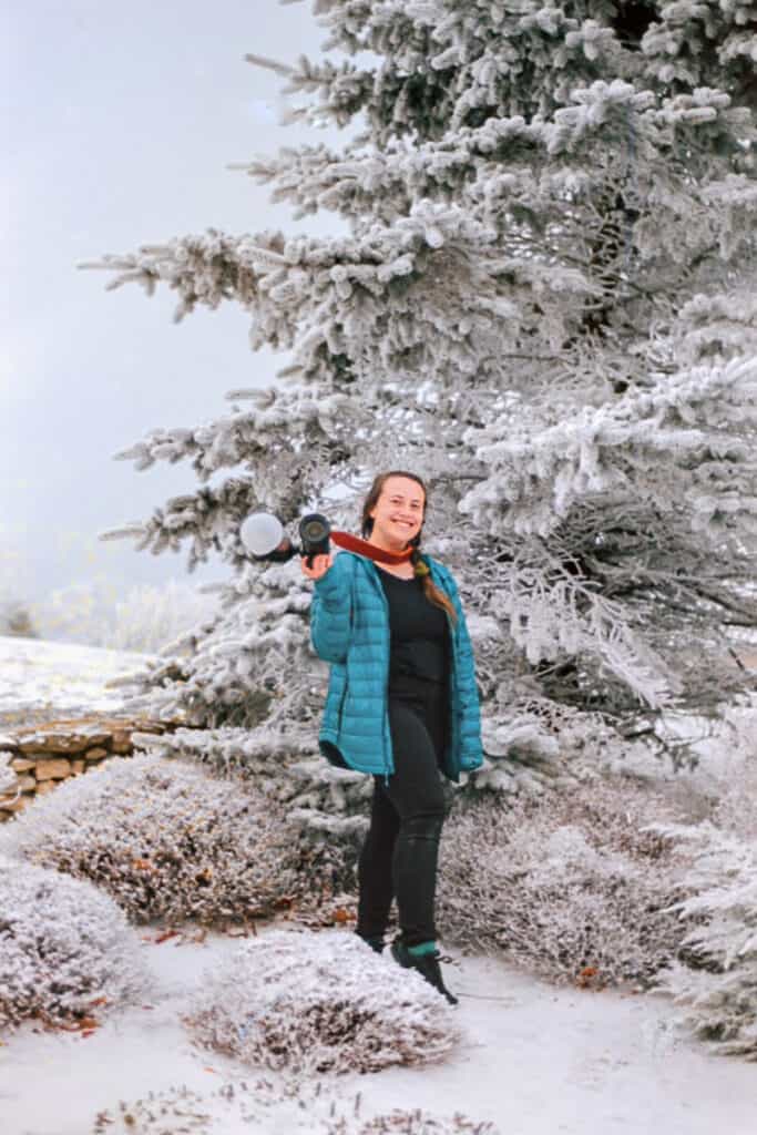 film wedding photographer in front of snowy tree