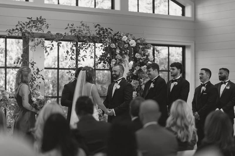 bride and groom standing at altar with guests in foreground
