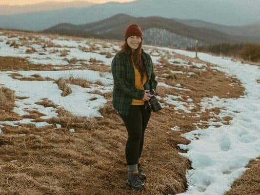 elopement photographer in north carolina standing on snowy mountain